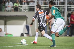 Bernard conduz a bola contra a marcação de jogador em Atlético 3 x 0 Palmeiras em 2012 (foto: Bruno Cantini/Atlético)