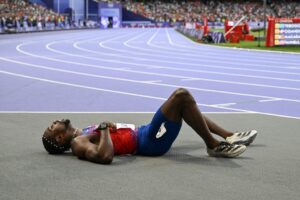 Noah Lyles no chão após final dos 200m (foto: Jewel SAMAD / AFP)