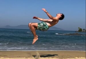 Hugo Calderano faz salto de ginástica na praia (foto: Reprodução)