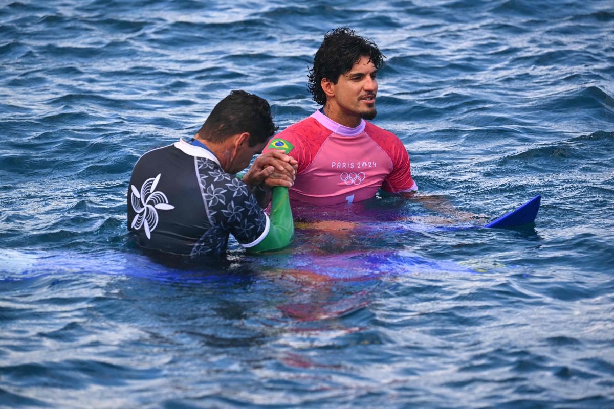 Medina no mar ao lado do treinador (foto: Jerome BROUILLET/AFP)