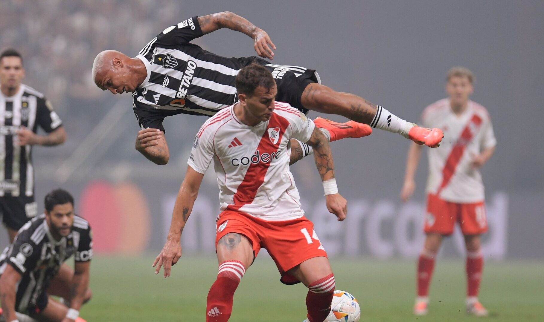 Disputa de bola entre González Pirez e Deyverson em Atlético x River Plate (foto: Douglas Magno/AFP)