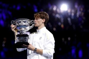 Jannik Sinner comemorando conquista do Australian Open com beijo no troféu (foto: Martin Keep/AFP)