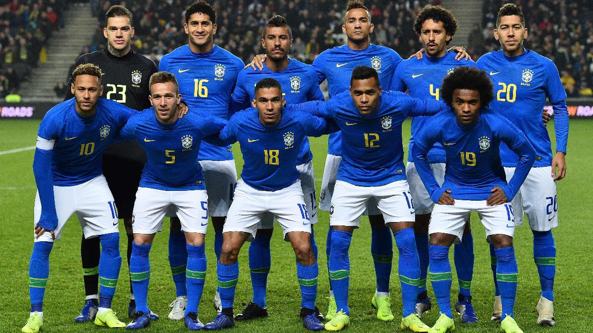 Neymar e Arthur Melo (abaixados, à esquerda) perfilados com a Seleção para amistoso em 2018 (foto: Glyn Kirk/AFP)