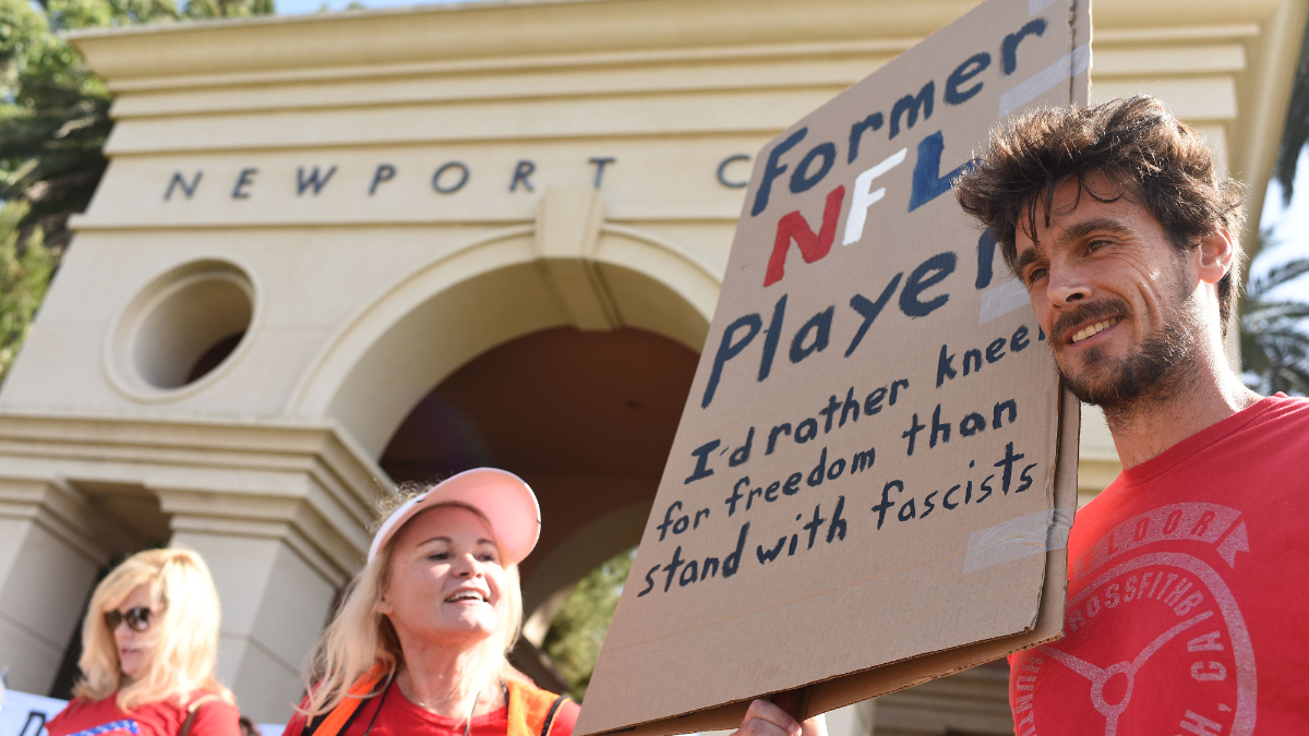 Em protesto contra Trump em 2017, Kluwe segura cartaz com os dizeres: