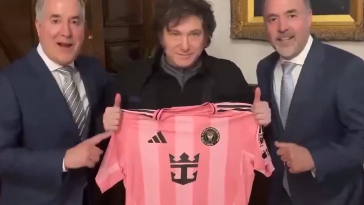 Milei entre os donos do Inter Miami exibindo camisa autografada por Messi (foto: Reprodução de vídeo)