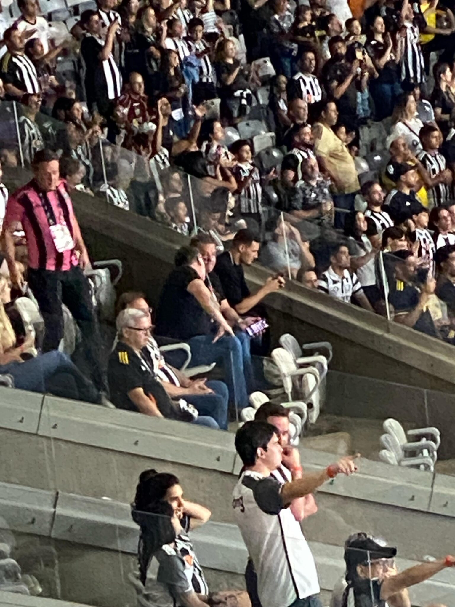 João Marcelo (de preto, usando o celular, próximo de um dos vidros), acompanha jogo do Atlético no Mineirão - (foto: Victor Moreira/TV Alterosa)